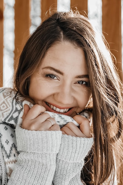 Close up portrait of a happy woman in cozy sweater and scarf.