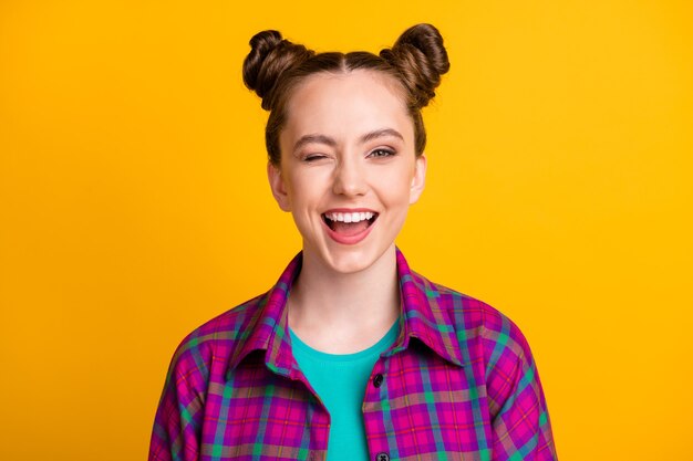 Close-up portrait of her she nice attractive pretty cheerful cheery flirty girl wearing checked shirt winking good mood isolated bright vivid shine vibrant yellow color background