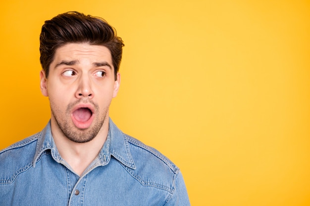 Close-up portrait of his he nice attractive handsome overwhelmed guy looking aside copy space opened mouth wow expression isolated over bright vivid shine vibrant yellow color wall