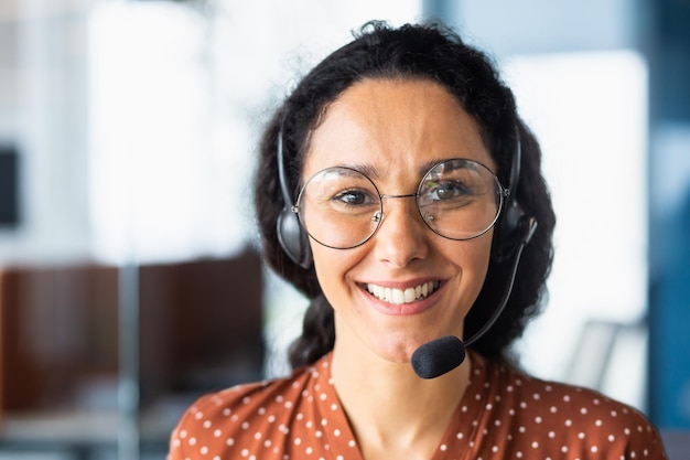 Close up portrait of latin american woman inside modern office with headset for video call woman