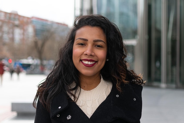 Close up portrait of a latin woman with curly hair posing outside