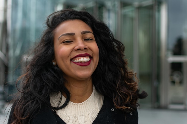 Close up portrait of a latin woman with curly hair posing outside