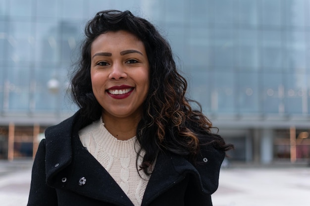 Close up portrait of a latin woman with curly hair posing outside