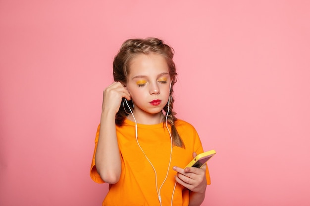 Close-up portrait of lovely charming cute cheerful cheery focused girl using cell web app isolated over bright vivid shine vibrant pink color wall