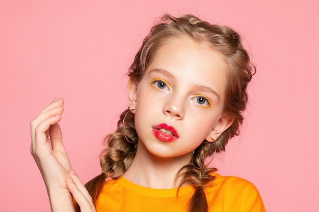 Close-up portrait of lovely sweet curious cheerful cheery smart clever girl isolated pink pastel color wall