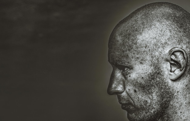 Close-up portrait of man against black background