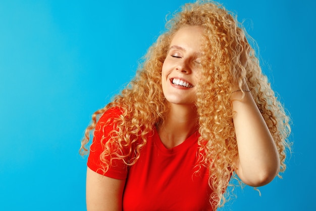 Close up portrait of a nice young woman with long curly hair, studio shot