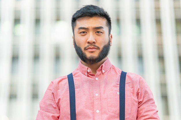 Close up portrait of a serious asian man outside