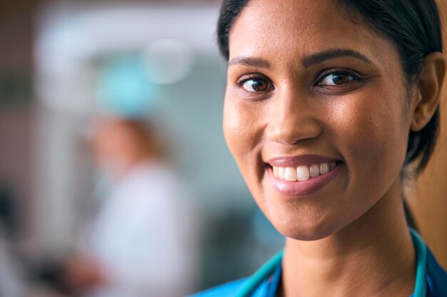 Photo close up portrait of smiling female doctor or nurse wearing scrubs and stethoscope in hospital