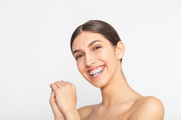 Close up portrait of Smiling Teen girl showing dental braces.Isolated on white background.