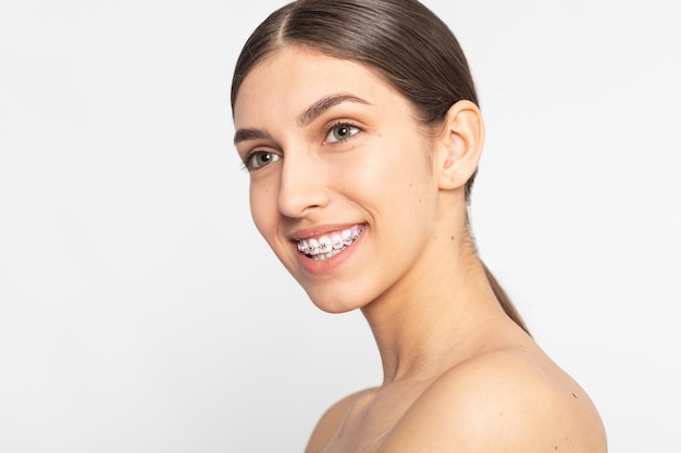 Close up portrait of Smiling Teen girl showing dental bracesIsolated on white background