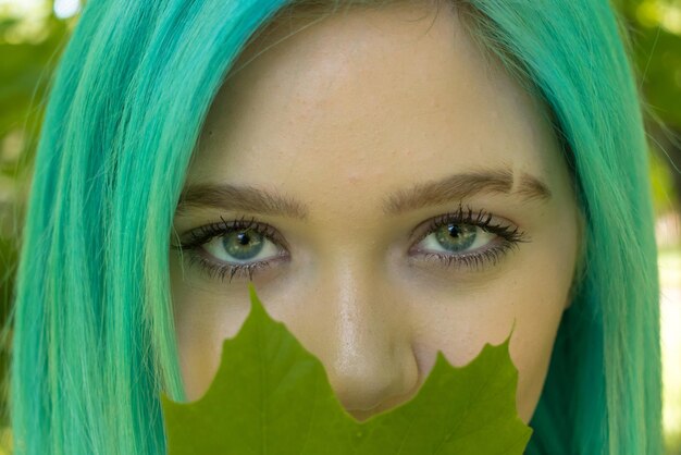 Photo close-up portrait of teenage girl holding leaf