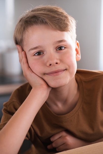 Close up portrait of teenager looking at camera with joyful smiling expression Blond boy