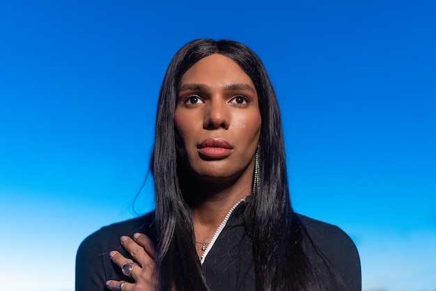 Close up portrait of a transgender black woman looking to the horizon during sunset outdoors