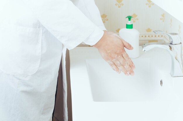 Close up portrait of washing hands in the bathroom to prevent virus transmission