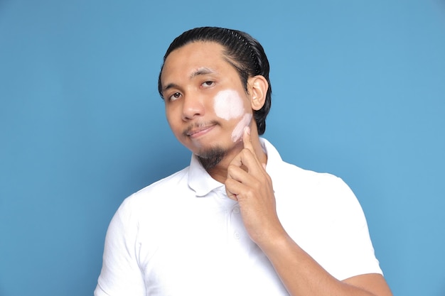 Close up portrait of young Asian man looking at camera using facial clay mask