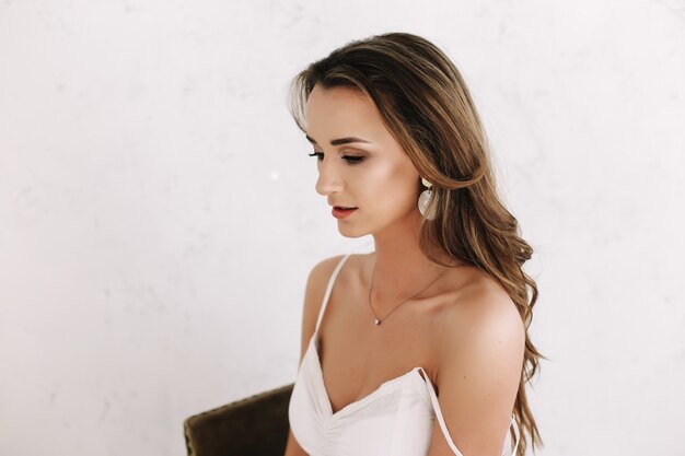 Close-up portrait of a young beautiful woman in white dress.