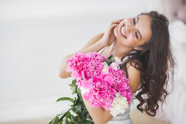 Close up portrait of young beautiful woman with flowers indoors