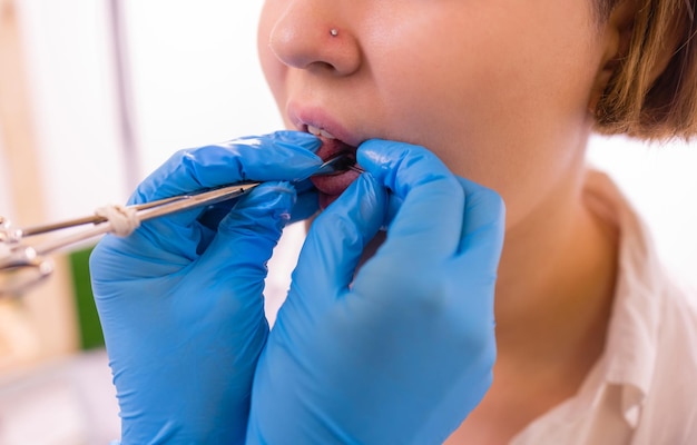 Close up portrait of young caucasian woman sticking out pierced tongue