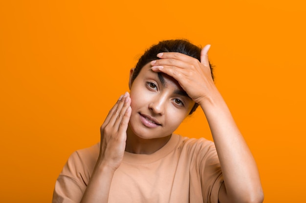 Close up portrait of young indian american woman doing facebuilding yoga face gymnastics yoga self massage