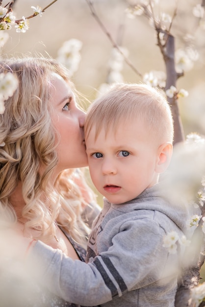 Close-up portrait of young mother with little blond son who are hugging