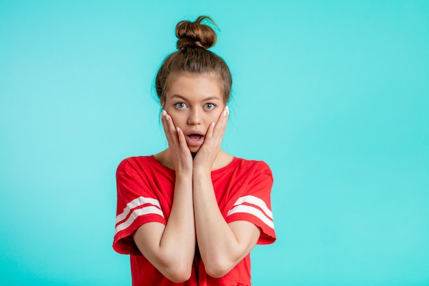 Close up portrait young shocked , stunned woman with hairbun and opened mouth