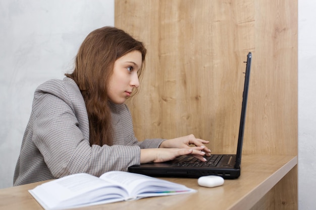 Close up portrait of a young woman looking at laptop thinking about something important