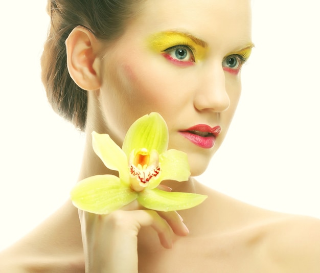 Photo close up portrait young woman with bright make up holding orchid