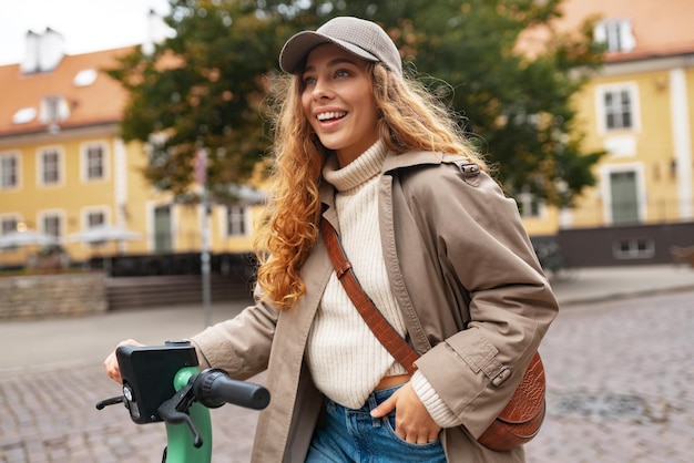 Close up portrait of young woman with electric scooter at the city