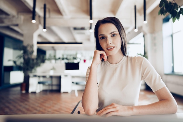 Close up portrait of a young woman working in office at the table