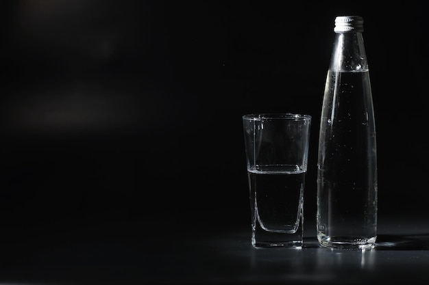 Close up pouring purified fresh drink water from the bottle on table in living room. Drinking water. Mineral vitamin water. Healthy, mineral-rich, refreshing water.