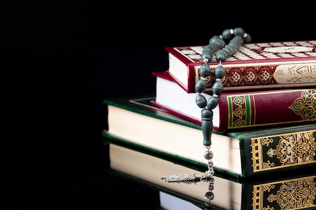 Close up prayer beads on pile of books 