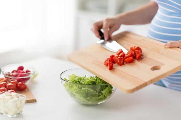 close up of pregnant woman cooking food at home