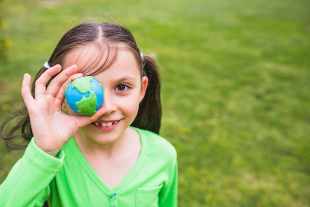 Close-up of a pretty girl holding clay globe in hand