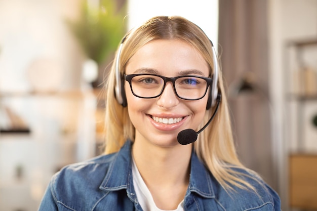 Close up of pretty young woman wearing headset and denim shirt