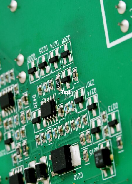 Close up of a printed green computer circuit board with identification numbers of components