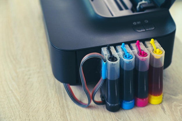 Photo close up printer with ink tank on the office desk