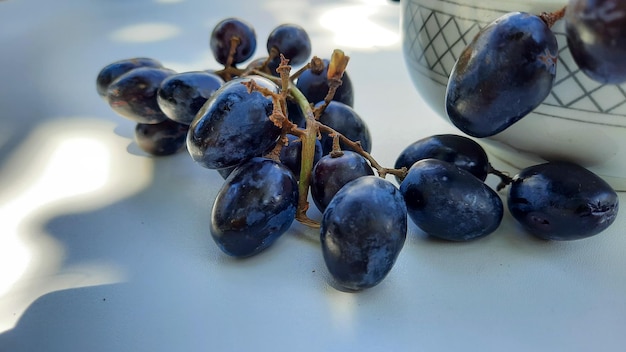 Close up, Purple grapes in bowl with stem isolated on white background 02