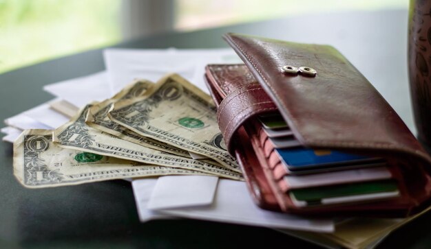 Close-up of purse and paper currencies on table