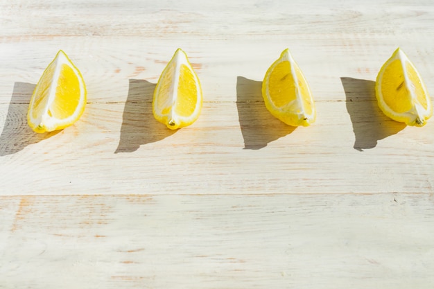 Close up of quarter lemons on wooden table. 