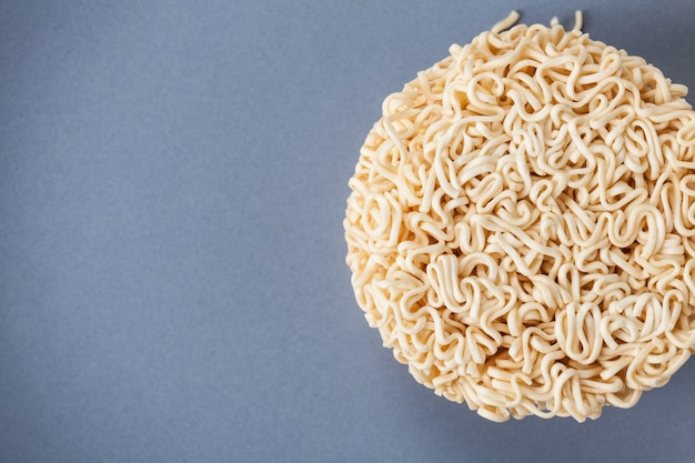 Close up Raw Instant noodles isolated on a gray plate with space for copy.