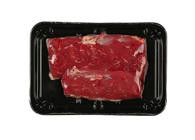 Close up raw lamb or mutton meat fillet cut steak vacuum sealed with black plastic film, isolated on white background, elevated top view, directly above