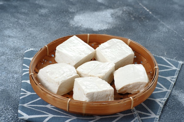 Close up of raw tahu putih or tofu in bamboo basket