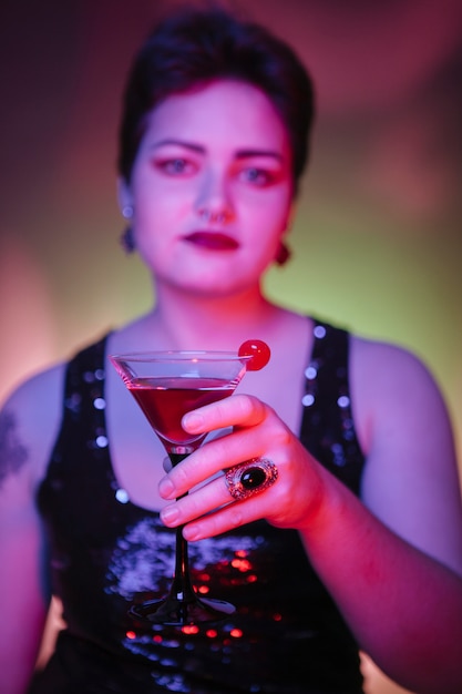 Close up of a red alcoholic beverage with a red cherry