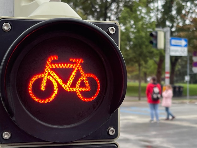 Close up of red bicycle traffic road lights in the city pedestrians on background