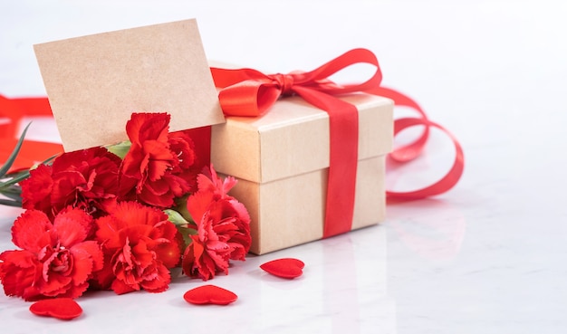 Close up of red carnation with gift box for Mother's Day greeting