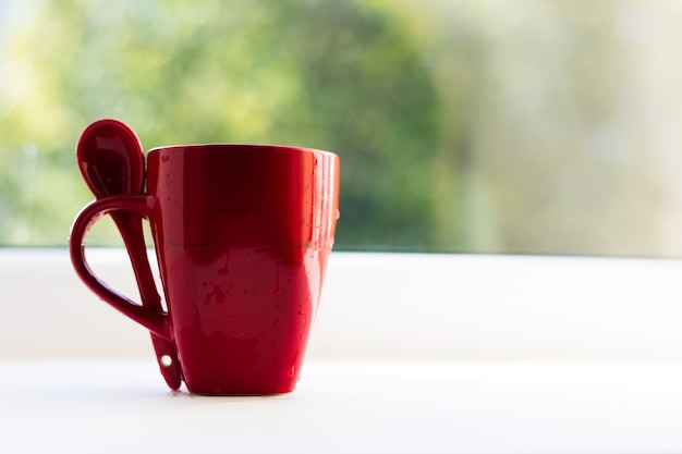 Close-up of red ceramic cup and spoon.