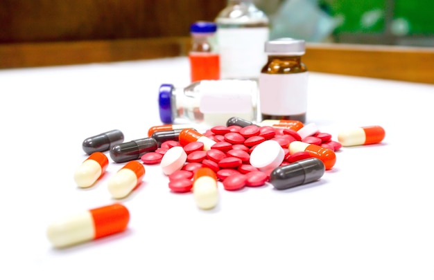 Close up of Red pill medicines and capsule place on white table with ampule blurry background