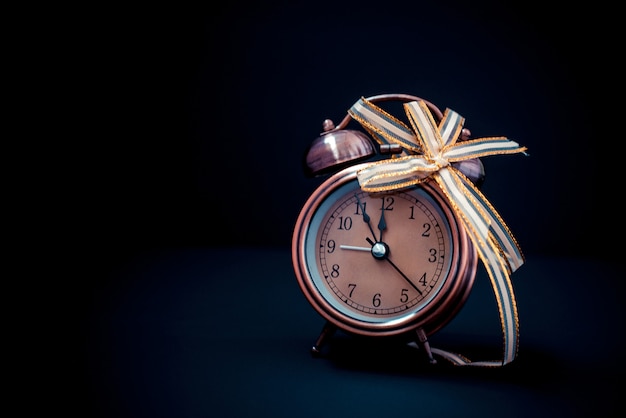 Close up of retro alarm clock on black Christmas background 