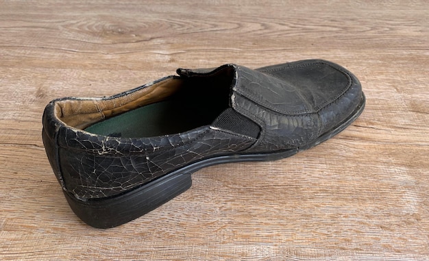 Close up retro old vintage leather shoe put on wooden table top